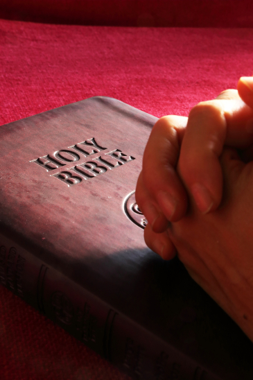 Pray specifically for the people in your church Bible and folded hands