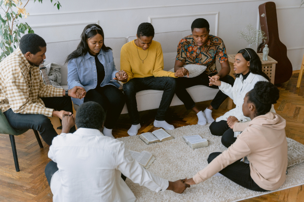 Imagine a group of people praying during their small group People praying in a small group